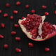 A fresh organic pomegranate slice with pomegranate seeds around it - PhotoDune Item for Sale