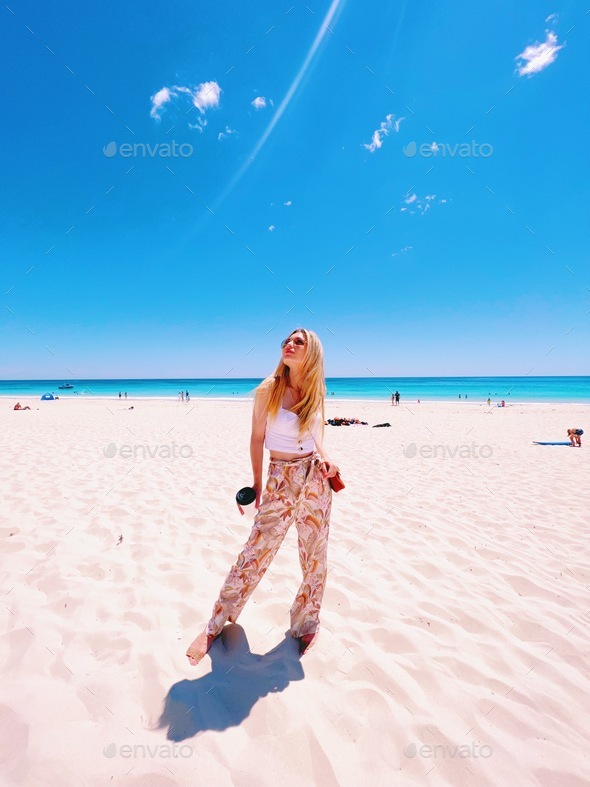 Beautiful blonde traveler girl and ocean  - Stock Photo - Images