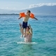 Happy father wearing a snorkeling mask and his son are standing in the water - PhotoDune Item for Sale