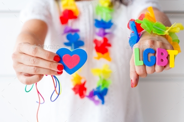 Woman with word lgbt on her hand, holding a colorful heart, rainbow, celebration, gender diversity