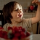 the boy happily looks at the strawberries. A child eats a berry - PhotoDune Item for Sale