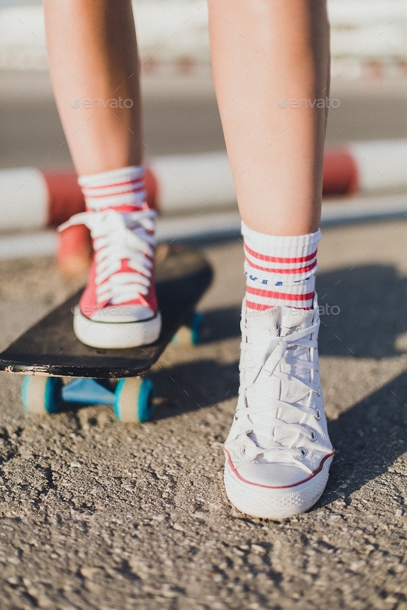 Girl on a skateboard.  Legs in sneakers close-up - Stock Photo - Images