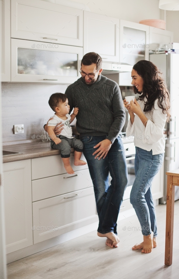 Happy family with a little boy in their new home apartment, mother father and their son at cozy home - Stock Photo - Images