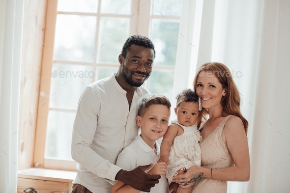 Portrait of candid friendly happy interracial family with two kids ...