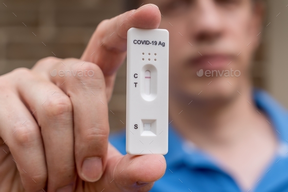 Man holding negative Covid-19 Antigen Rapid test result. Rapid diagnostic test