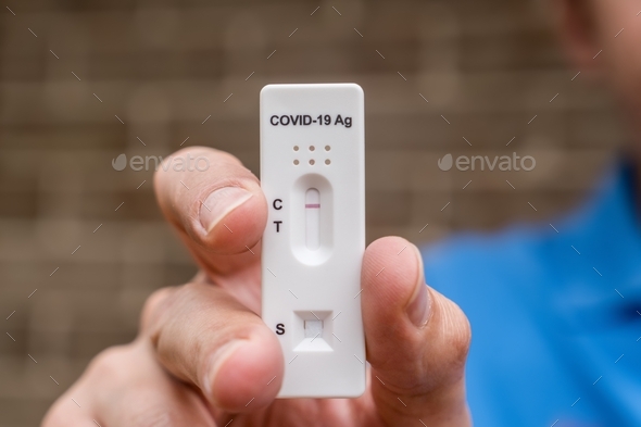 Man holding negative Covid-19 Antigen Rapid test result. Rapid diagnostic test