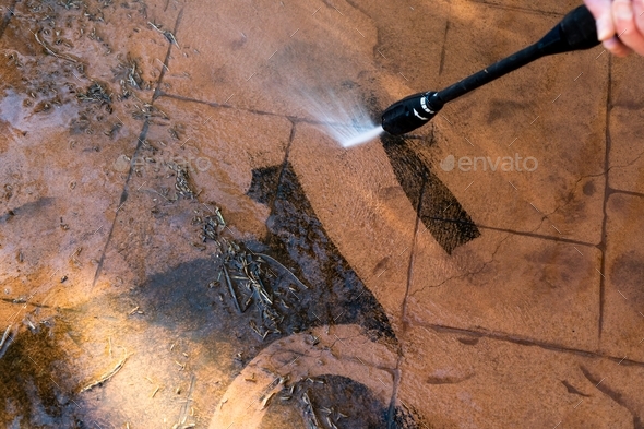 Washing the backyard tiles with high pressure cleaner washer. Spring clean up
