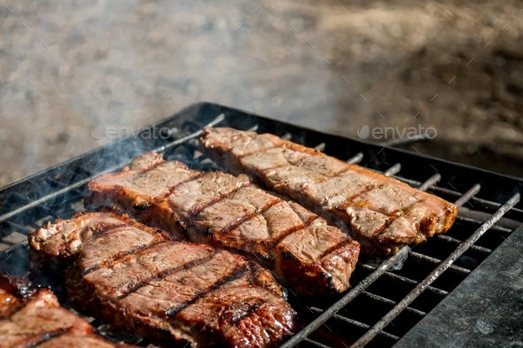 Bbq Grilling Meat Beef Steaks On A Cast Iron Grill Over The Campfire