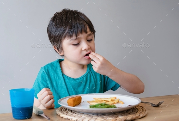 Portrait 5 year old kid boy having homemade fish finger and french ...