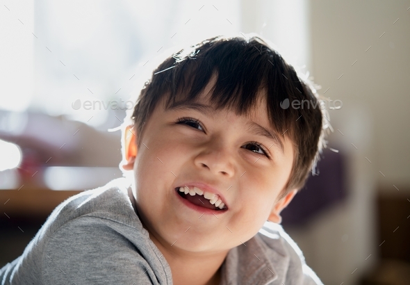 Happy kid looking up with smiling face, Healthy child relaxing at home