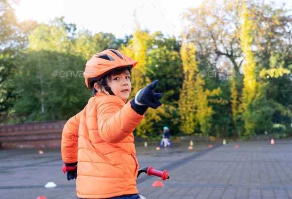 kid learn to ride a bike young boy practicing how to ride a bicycle.Child in helmet riding a cycling