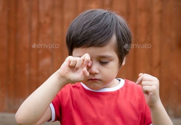 boy is having allergy rubbing his eye, Kid scratching his eyes ,Child having allergy itchy face