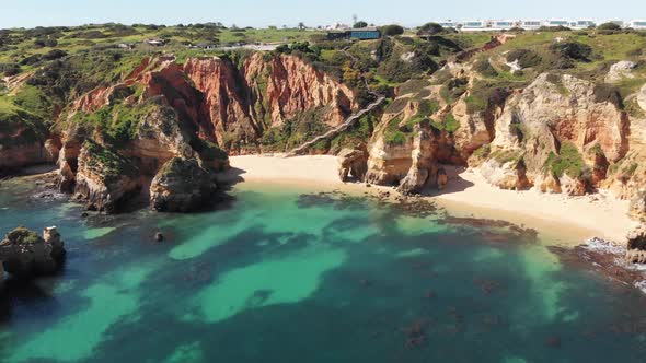 Pristine Camilo Beach in Lagos Idyllic coastline in Algarve, Portugal - Aerial establishing shot alt