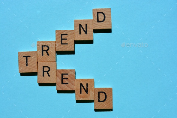 Trend, words in 3D wooden alphabet letters isolated on blue background