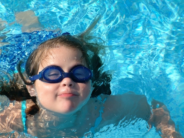 Little girl wearing swim goggles in swimming pool Stock Photo by JosieElias