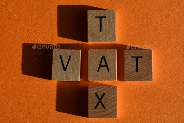 VAT (acronym for Value Added Tax) and Tax in 3d wooden alphabet letters on orange background