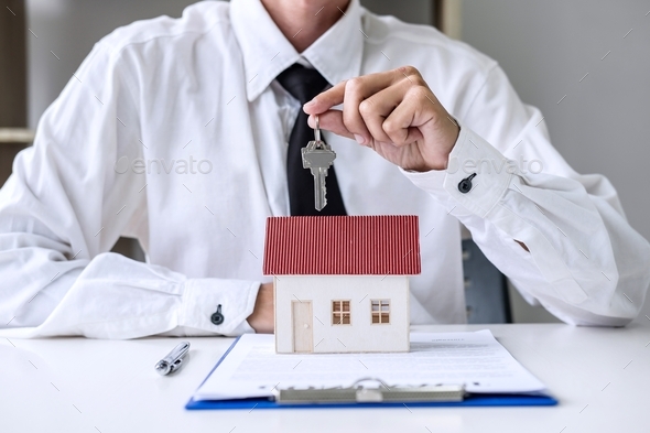 Real estate agent Sales manager holding filing keys to customer after signing rental lease contract