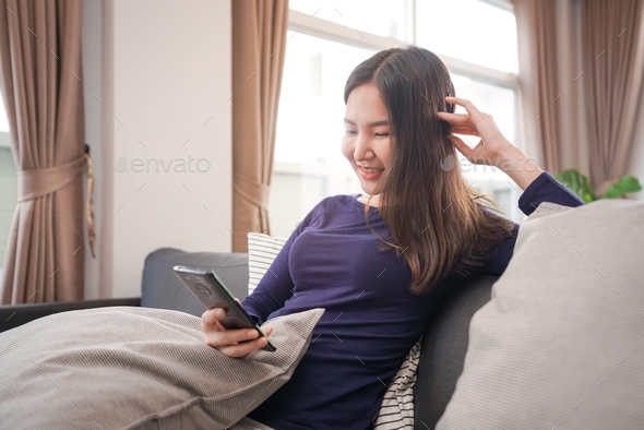 Young woman in casual clothes using smartphone to chatting with friends and shopping online