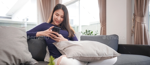 Young woman in casual clothes using smartphone to chatting with friends and shopping online