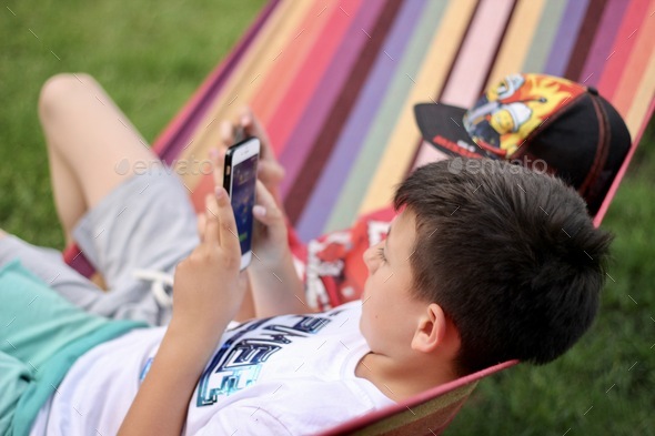 Kids, boys, friends, playing, gaming, outdoors, leisure, recreation, relax, using mobile, hammock