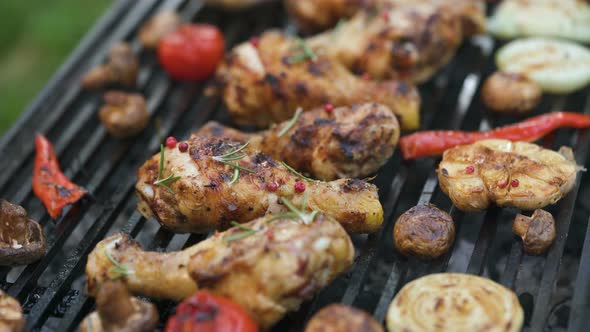 Closeup of a Barbecue Grill with Chicken Legs and Vegetables