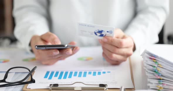 Woman Holding Plastic Credit Card and Mobile Phone in Her Hands in Office  Movie Slow Motion alt