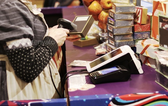 The seller scans the barcode of the goods from the store. Payment by cash register.