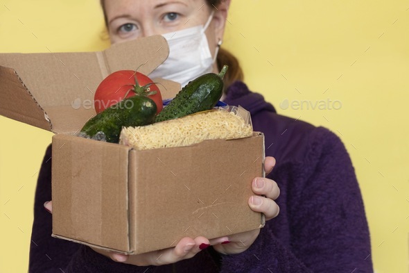 Coronavirus food delivery. Volunteer brings a box of food. background,