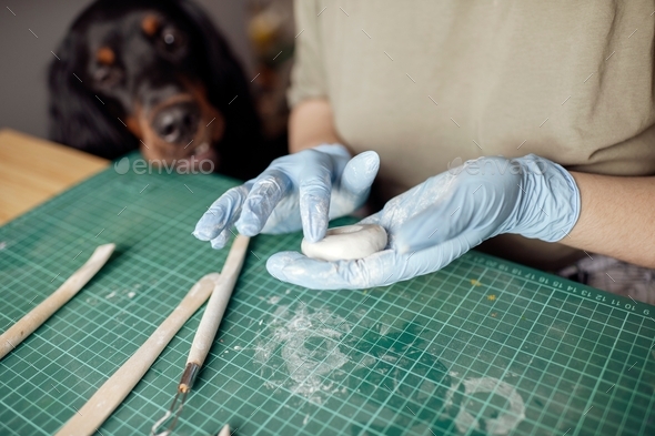 ↟ ✓ Young girl and her assistant dog work with polymer clay