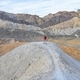 Colorful minimalism hiker on top a hill in Death Valley desert badlands of the 20 mile mile canyon  - PhotoDune Item for Sale
