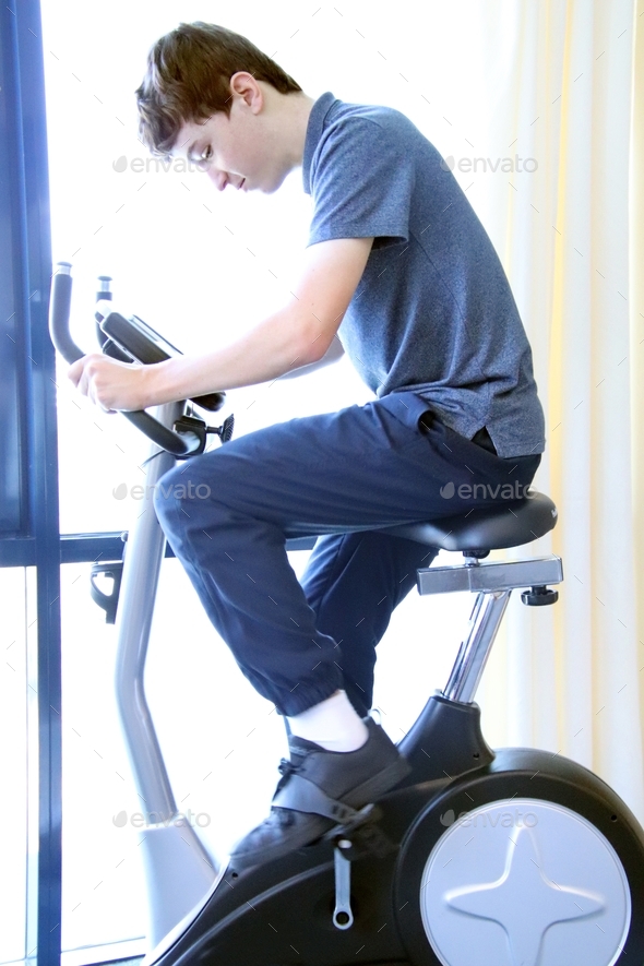 Teenage boy using an indoor exercise bike
