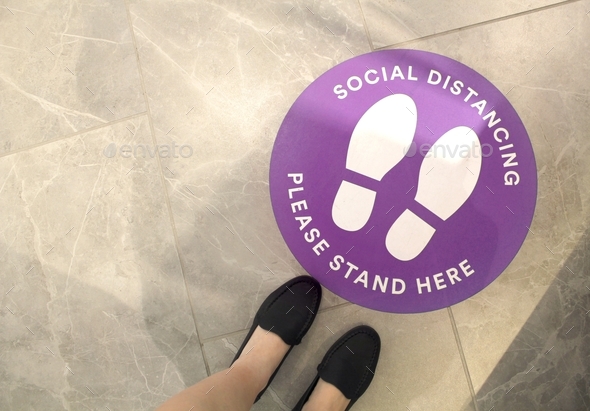 Purple social distancing sign on the floor