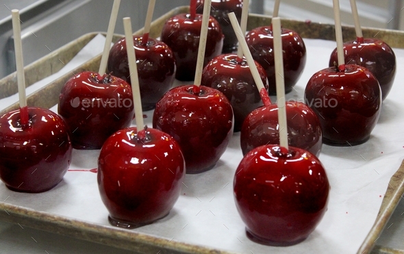 Red toffee apples or candy apples in production at the bakery
