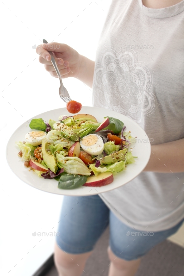 Young lady eating salad for lunch - Stock Photo - Images