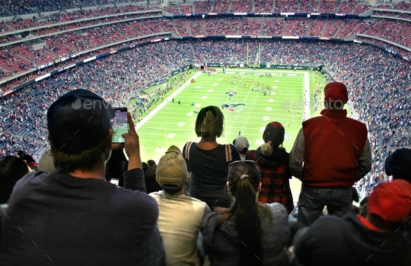 An audience of sports fans watching an NFL football game in a stadium
 - Stock Photo - Images