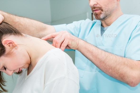 neurologist doctor examines cervical vertebrae of the female patient spinal column in medical clinic