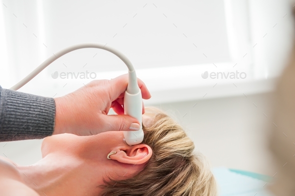  woman doctor scanning head vessels on the head with ultrasound device scan
