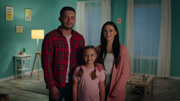 Portrait of Young Family Standing In Living Room alt