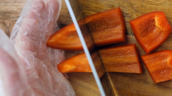 The Chef Cuts Into Squares a Sweet Red Pepper with a Professional Knife alt