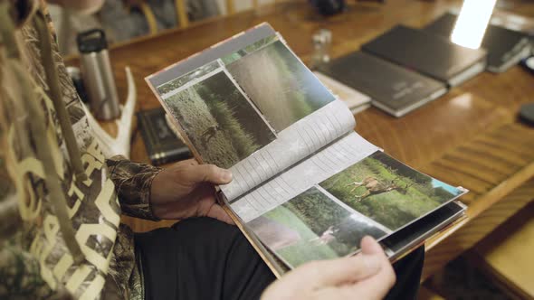 Hunter looking at trail cam pics of whitetail deer alt