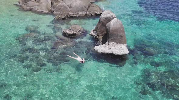 Young Caucasian Woman Snorkeling in Pristine Crystal Clear Shallow Water Beside Rocky Shoreline in alt