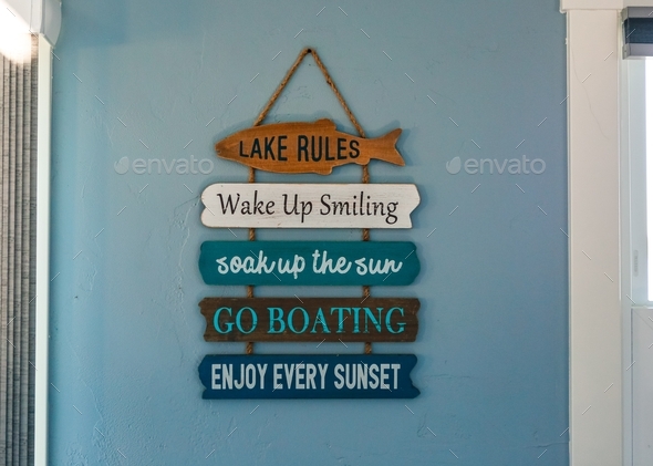 Lake rules sign on blue wall: wake up smiling, soak up the sun, go ...