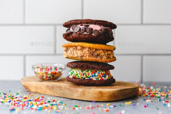 Bright and colorful ice cream cookie sandwiches with sprinkles and white brick background - Stock Photo - Images
