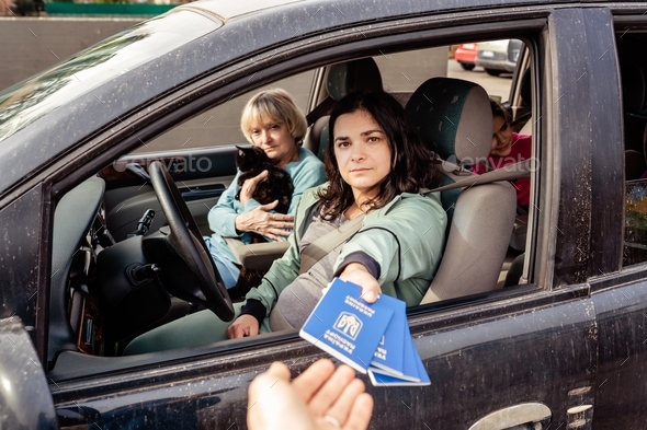 Family in car holding Ukrainian passports fleeing from Ukraine crossing the border