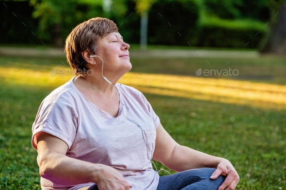 Plus size body positivity woman doing meditation on yoga mat with