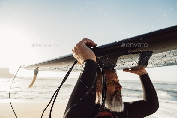 Senior with surfboard - Stock Photo - Images