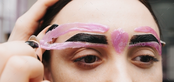 eyebrow waxing. removal of unwanted hair on the eyebrows.