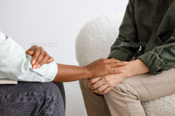 mental support to hold hands, handshake. An African-American female psychologist holds an