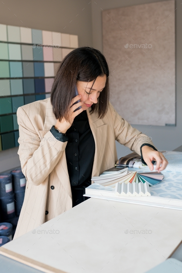 Woman designer choosing wallpaper from catalog for home renovation - Stock Photo - Images