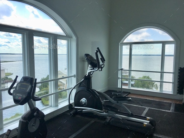 Exercise cardio machines in large room with big windows and ocean view